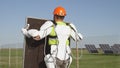 Male technician in exoskeleton carrying photovoltaic panel