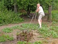 A man hardly drags the old harrow by the rope in the courtyard. Rural life