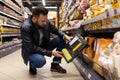 a man in a hardware store chooses a set of tools for painting. Roller and paint container