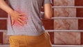 A man has back pain, walking up the stairs and using the handle on his waist that Royalty Free Stock Photo