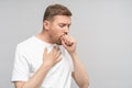 Man has bad cough, sore throat chest pain isolated on studio grey background, bronchitis, tracheitis