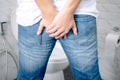 Man has Diarrhea Holding his Butt in the bathroom Royalty Free Stock Photo