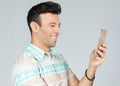 Man has fun using his cell phone. Handsome brazilian male wears