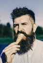 Man has ice cream. Man with long beard enjoy ice cream. Sweet tooth concept. Bearded man with ice cream cone Royalty Free Stock Photo