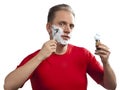 Man has a shave- with the razor and a small brush Royalty Free Stock Photo