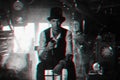 man in a hat and with a cane cosplays a character of a steampunk computer game. Inventor's cyberpunk concept with 3d