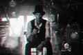 man in a hat and with a cane cosplays a character of a steampunk computer game. Inventor's cyberpunk concept with 3d Royalty Free Stock Photo