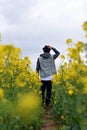 Man in the hat goes in rapeseed field Royalty Free Stock Photo