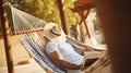 Man in hat in a hammock with book on a summer day. Lazy time. Generative AI Royalty Free Stock Photo