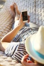 Man in hat in a hammock with mobile phone on a summer day Royalty Free Stock Photo