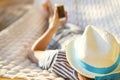 Man in hat in a hammock with mobile phone on a summer day Royalty Free Stock Photo