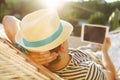 Man in hat in a hammock with tablet computer on a summer day Royalty Free Stock Photo