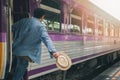 A man with hat holding handrail in train at the open door. People travel local transport Royalty Free Stock Photo