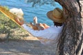 Man in hat relaxing in a hammock on pine tree in Crimea a summer day Royalty Free Stock Photo