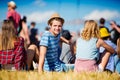 Man with hat, teenagers, summer festival, sitting on grass Royalty Free Stock Photo