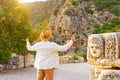 Man in hat and white shirt, the traveler looks with surprise, raising his hands up at the ancient unique famous places of Turkey,