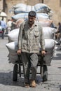 A man hauls a heavy load of sacks through the Khan el Khal'ili Bazaar in Cairo, Egypt.