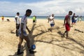 Cuban soccer player walking on beach and pushing ball with a relaxed attitude