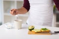 Man having breakfast and adding sugar to coffee