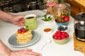 Man having breakfast with a cup of coffee and pancakes with berries