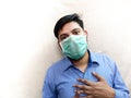Man having chest pain difficulty in breathing wear face mask hands on chest Royalty Free Stock Photo