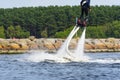 Man having fun on Flyboard. Flyboarding in a sunny summer day at river in harbor. Extrime water activity flyboard.