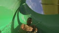 Man having fun sliding down a waterslide in public swimming pool