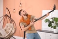 Young man having fun while vacuuming at home Royalty Free Stock Photo