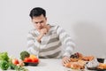 Man having hard choice between healthy and unhealthy food