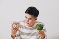 Man having hard choice between healthy and unhealthy food Royalty Free Stock Photo