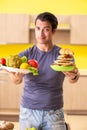 The man having hard choice between healthy and unhealthy food Royalty Free Stock Photo