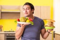 The man having hard choice between healthy and unhealthy food Royalty Free Stock Photo