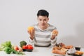 Man having hard choice between healthy and unhealthy food Royalty Free Stock Photo