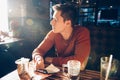 Man having morning breakfast with coffee in diner cafe and using his mobile phone.