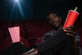 Man having popcorn and cold drink while watching movie