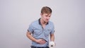 Man having a stomachache on a gray background