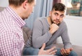 Man having unpleasant talk with colleague on couch