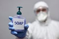 Man in hazmat holding soap dispenser Royalty Free Stock Photo