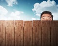 A man head behind wooden fence