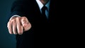 Man without head standing and shows outstretched hand with Pointing Finger on dark background. Royalty Free Stock Photo