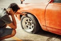 Man headache when car breakdown and wheel flat tire in parking Royalty Free Stock Photo