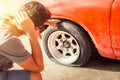 A man headache when car breakdown and wheel flat tire in parking