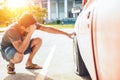 A man headache when car breakdown and wheel flat tire on the road in the parking