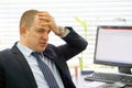 Man with a headache in front of the computer Royalty Free Stock Photo