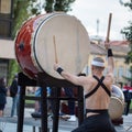 Man with Headband Playing Vertical Drum of Japanese Musical Tradition during a Public Outdoor Event