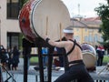 Man with Headband Playing Vertical Drum of Japanese Musical Tradition during a Public Outdoor Event