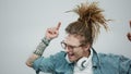 Man with headphones dancing on grey background. Guy gesturing hands during dance Royalty Free Stock Photo