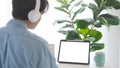 Man with headphones and digital tablet with blak screen on working table background for mock up, template Royalty Free Stock Photo