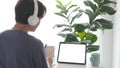 Man with headphones and digital tablet with blak screen on working table background for mock up, template Royalty Free Stock Photo