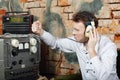 Man in headphones knocks on power source to radio receiver Royalty Free Stock Photo